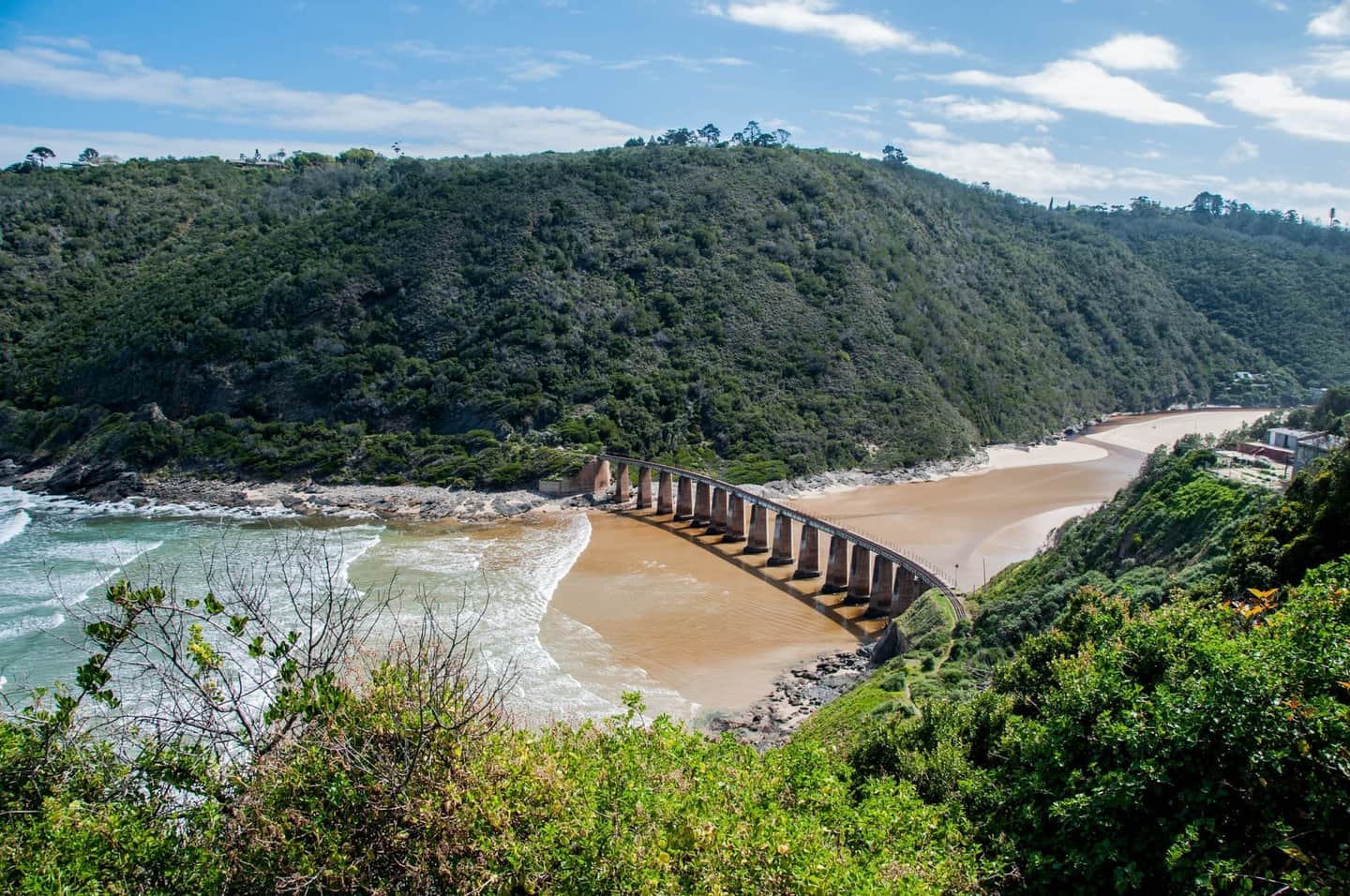 Forested coastline of the Garden Route with turquoise Indian Ocean and rocky outcrops near Knysna