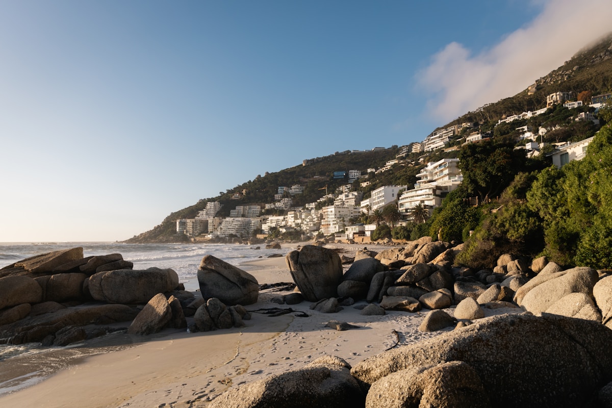 Clifton Beach at low tide with boulders and white buildings on the hillside, Cape Town, South Africa
