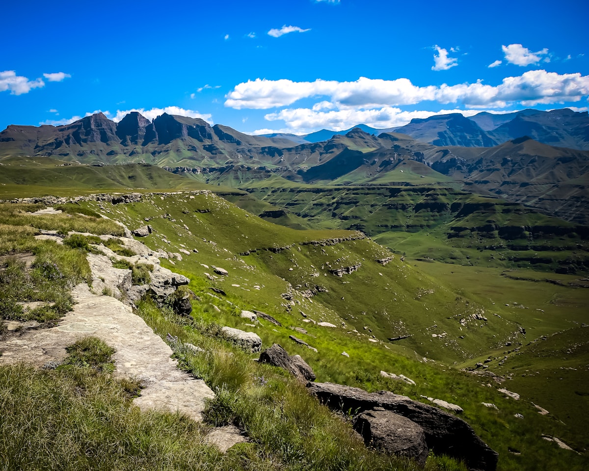 The high basalt cliffs of the Drakensberg escarpment rising above green foothills, KwaZulu-Natal, South Africa