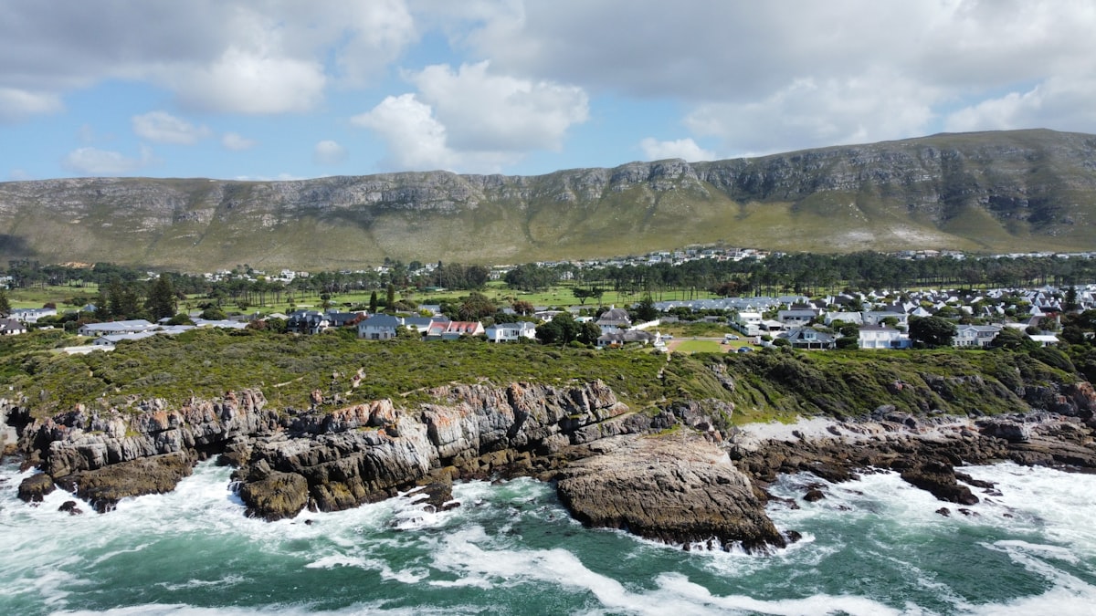 Aerial view of Hermanus coastline with rocky shores and the Whale Coast mountains
