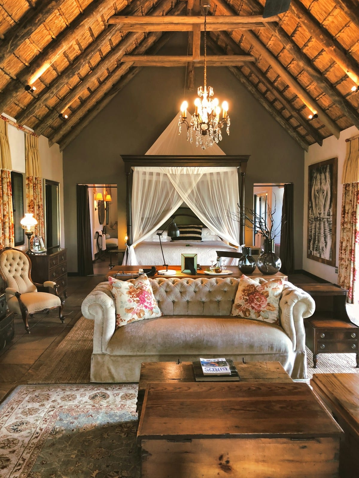Luxury suite interior at Sabi Sabi Earth Lodge, with thatched ceiling, four-poster bed, and candlelight, South Africa