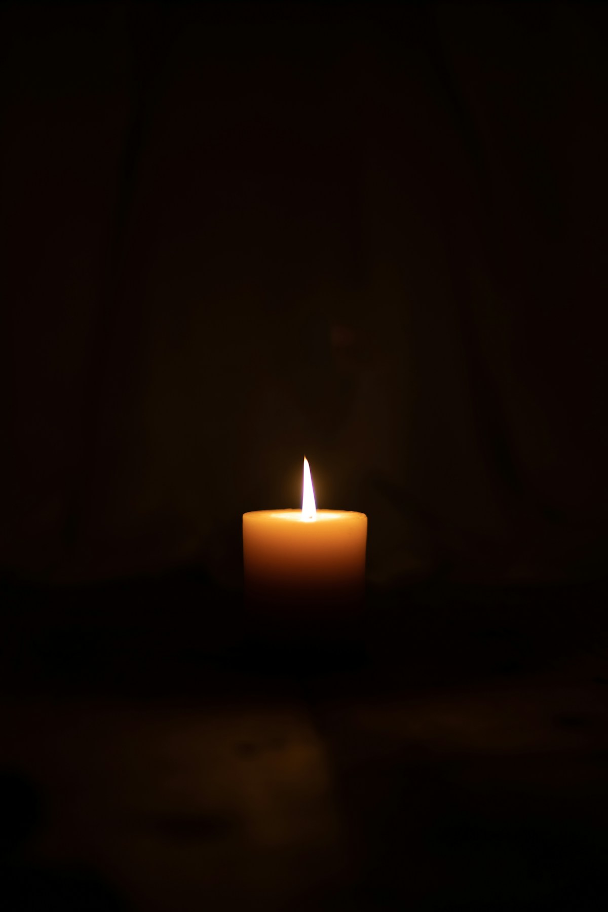 A single lit candle in a dark room during a power cut