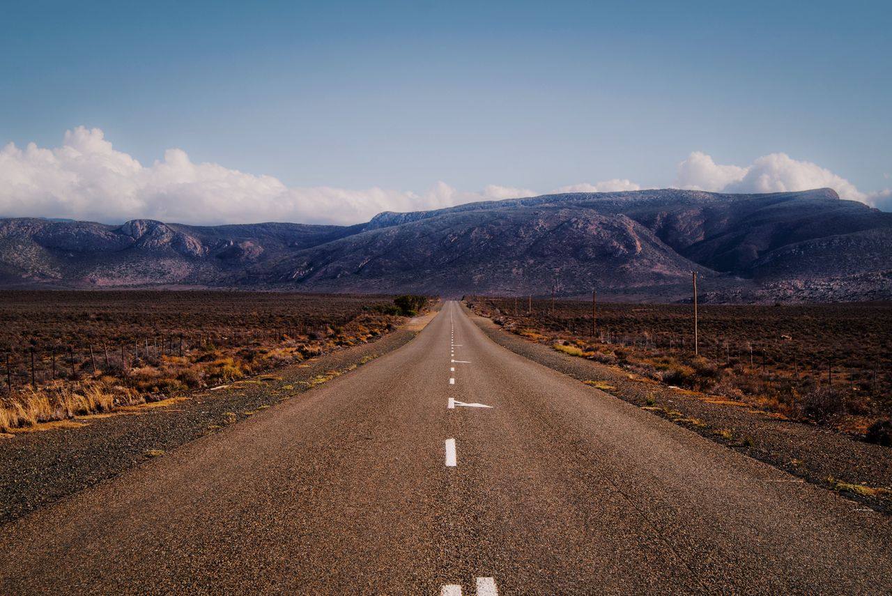 Empty tarred road crossing the Karoo with mountains ahead, on the Cape Town to Johannesburg route, South Africa