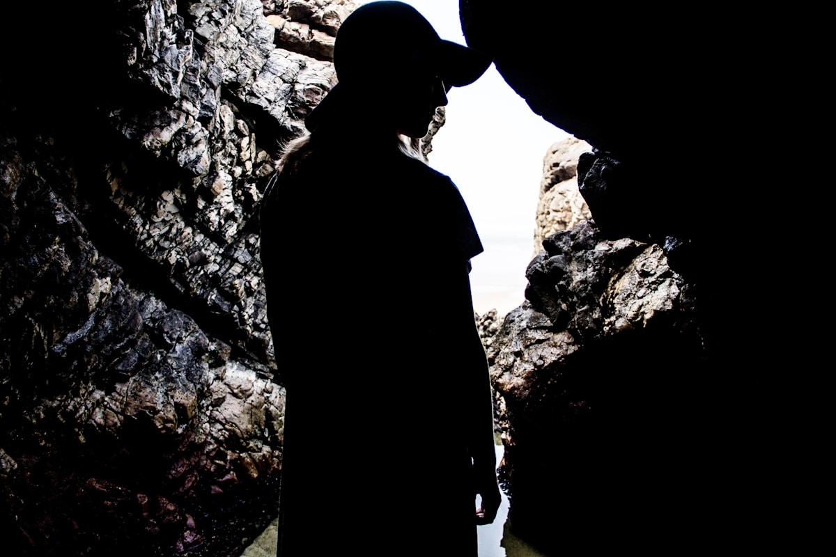 Person silhouetted in rocky sea cave at Robberg Peninsula, Plettenberg Bay, South Africa