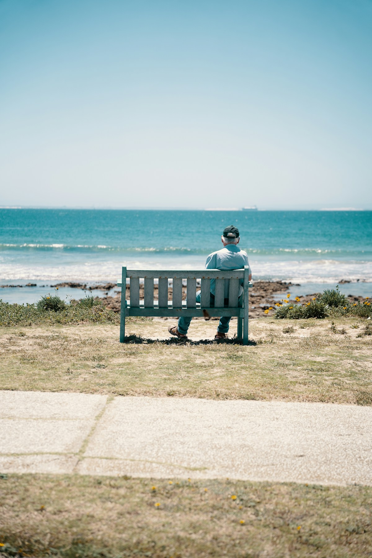 Person on bench looking out at the Indian Ocean from Port Elizabeth seafront, Gqeberha, South Africa