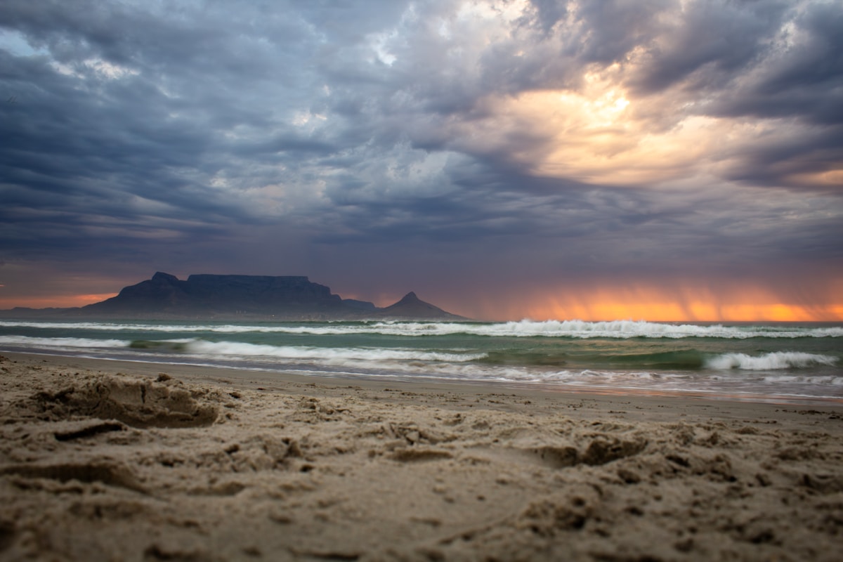 Dramatic sunset over the ocean with Table Mountain — South Africa in March